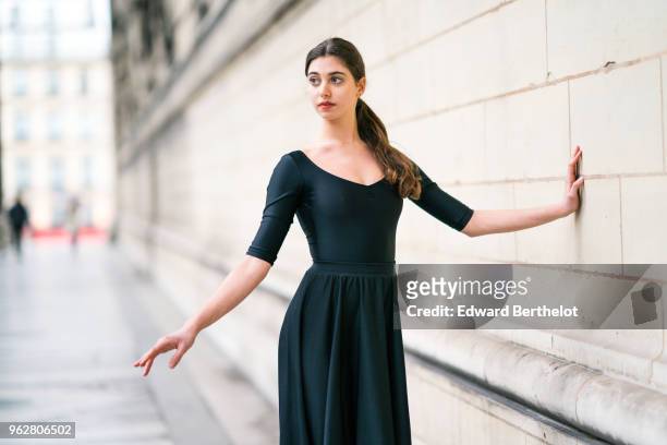 Amanda Derhy, ballet dancer, performs ballet moves and wears a black dress, on April 2, 2018 in Paris, France.