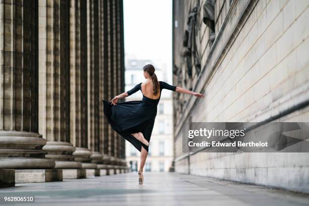 Amanda Derhy, ballet dancer, performs ballet moves and wears a black dress, on April 2, 2018 in Paris, France.