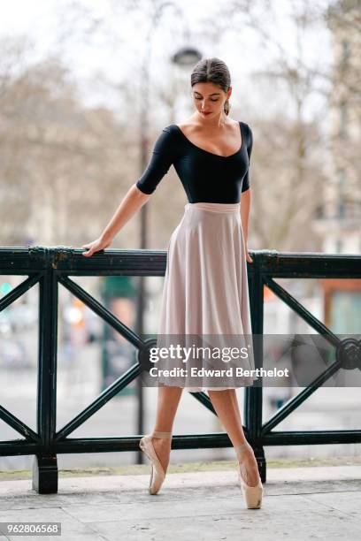 Amanda Derhy, ballet dancer, performs ballet moves and wears a black dress, on April 2, 2018 in Paris, France.