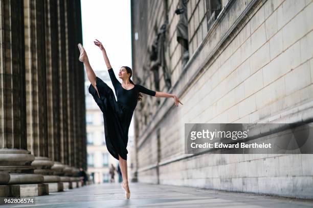 Amanda Derhy, ballet dancer, performs ballet moves and wears a black dress, on April 2, 2018 in Paris, France.