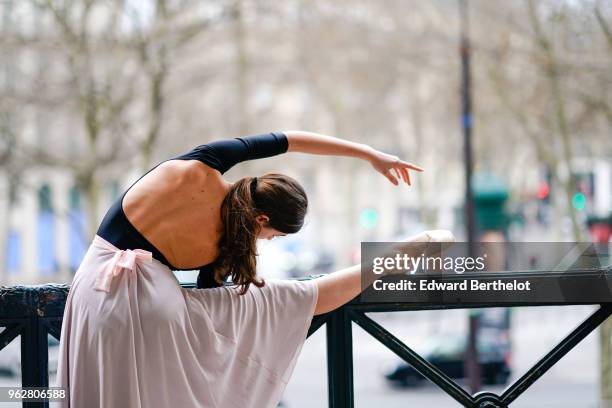 Amanda Derhy, ballet dancer, performs ballet moves and wears a black dress, on April 2, 2018 in Paris, France.