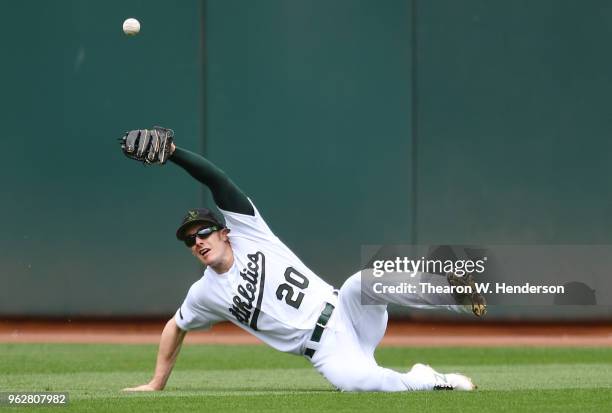 Mark Canha of the Oakland Athletics watches the ball kick off his glove for a single off the bat of David Peralta of the Arizona Diamondbacks in the...