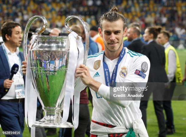 Real Madrid's Gareth Bale poses for a photo with the trophy after winning the UEFA Champions League final football match against Liverpool FC at the...