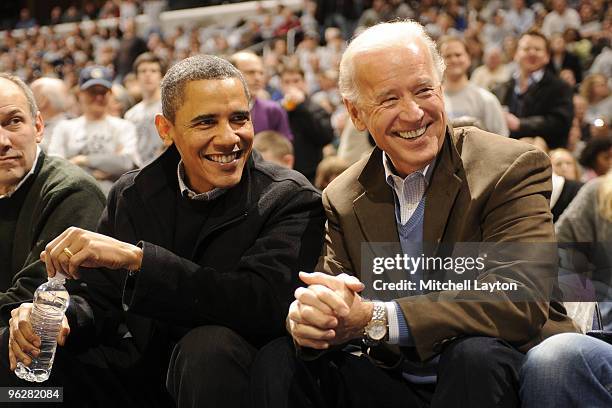 President of the United States Barack Obama and Vice President Joe Biden talk during a college basketball game between Georgetown Hoyas and the Duke...