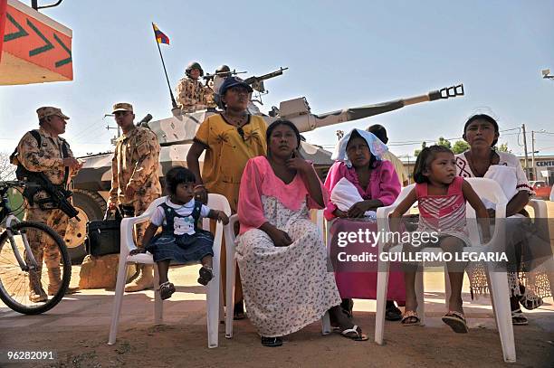 Colombia's Wayuu indigenous people sit next to Colombian soldiers during a meeting between the army and villagers of the town of Uribia, in La...