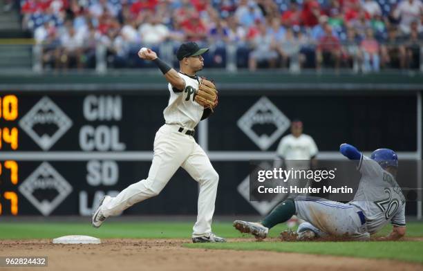 Cesar Hernandez of the Philadelphia Phillies turns a double play in the ninth inning as Josh Donaldson of the Toronto Blue Jays slides under the...