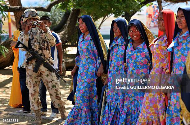Colombian soldier takes a picture of Colombian Wayuu indigenous women during a meeting between the army and villagers of the town of Uribia, in La...
