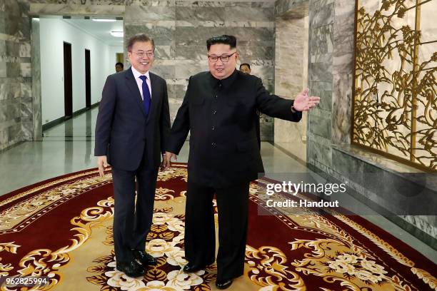 In this handout image provided by South Korean Presidential Blue House, South Korean President Moon Jae-in shake hands with North Korean leader Kim...