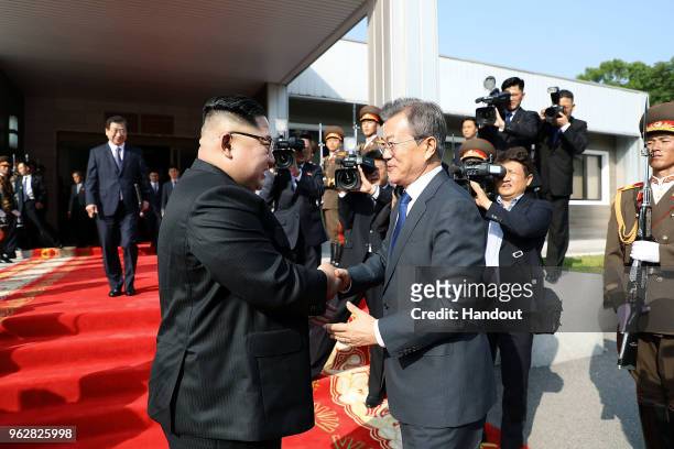 In this handout image provided by South Korean Presidential Blue House, South Korean President Moon Jae-in shake hands with North Korean leader Kim...