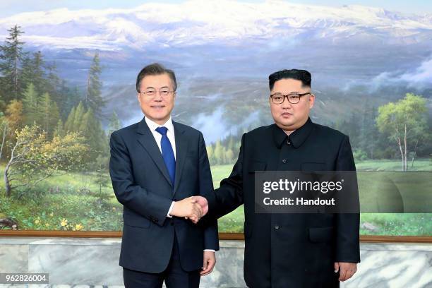 In this handout image provided by South Korean Presidential Blue House, South Korean President Moon Jae-in shake hands with North Korean leader Kim...