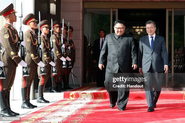 In this handout image provided by South Korean Presidential Blue House, South Korean President Moon Jae-in walks with North Korean leader Kim Jong-un...