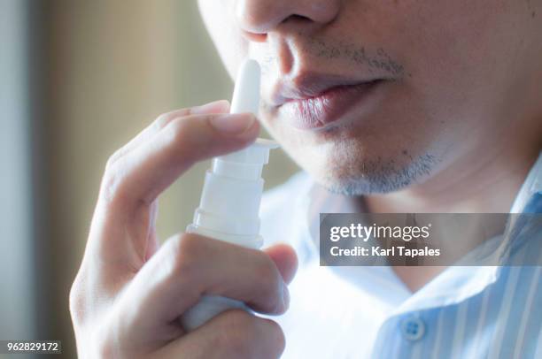 a patient is using a nasal spray - nasenspray stock-fotos und bilder
