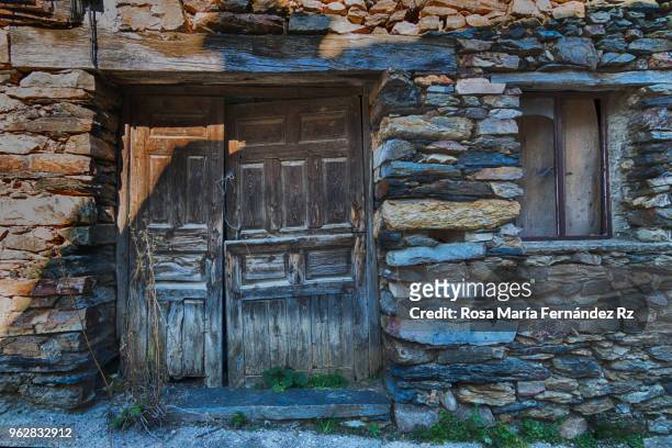 old and abandoned front door in valverde de los arroyos. a village that conserves their traditional architecture bses on the slate - rock. cuenca, castila la mancha, spain. europe - slate rock stock-fotos und bilder