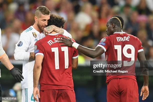 Sergio Ramos of Real Madrid and Sadio Mane of Liverpool console Mohamed Salah of Liverpool as he leaves the pitch injured during the UEFA Champions...