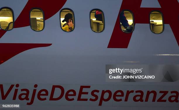 Colombia's James Rodriguez speaks on his mobile phone inside a plane at the military airport in Bogota on May 26, 2018 as the national team leaves...