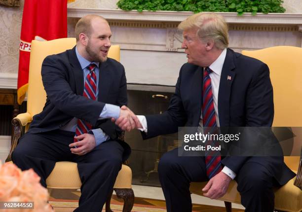 President Donald Trump shake hands during a meeting with Joshua Holt after his return to the U.S. At the White House on May 26, 2018 in Washington,...