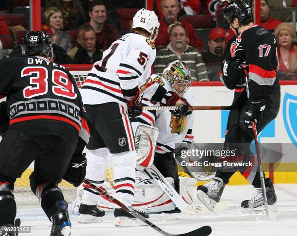 Cristobal Huet of the Chicago Blackhawks makes a save despite traffic created by teammate Brian Campbell and Patrick Dwyer and Rod Brind'Amour of the...