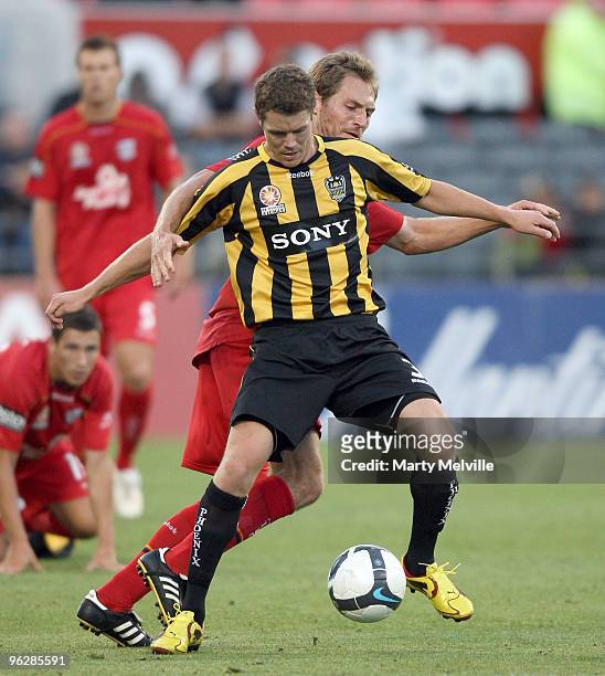 Tony Lochhead of the Phoenix gets tackled by Adam Hughes of Adelaide during the round 25 A-League match between Wellington Phoenix and Adelaide...