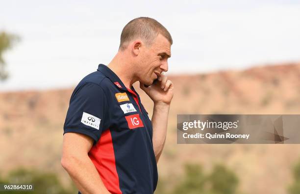 Demons head coach Simon Goodwin speaks on the phone during the round 10 AFL match between the Melbourne Demons and the Adelaide Crows at Traeger Park...