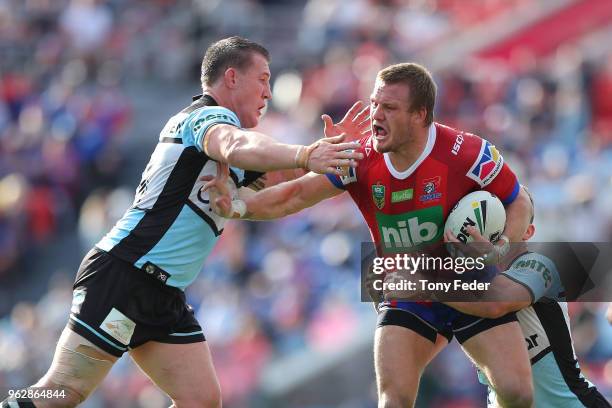 Nathan Ross of the Knights is tackled by Paul Gallen of the Sharks during the round 12 NRL match between the Newcastle Knights and the Cronulla...