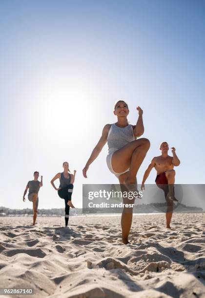 group of people doing aerobics at the beach - aeróbica imagens e fotografias de stock