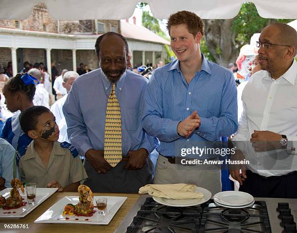 Prince Harry and Prince Seeiso of Lesotho taste some hot spicey food at a garden party at the Garrison Museum on January 30, 2010 in Bridgetown,...