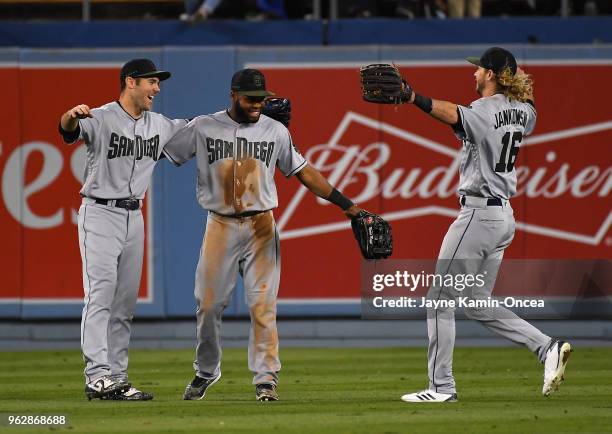 Matt Szczur, Manuel Margot and Travis Jankowski of the San Diego Padres celebrate after defeating the Los Angeles Dodgers at Dodger Stadium on May...