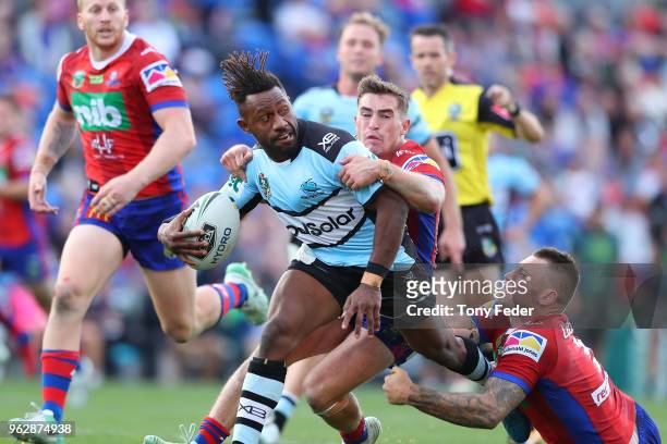 James Segeyaro of the Sharks is tackled by Connor Watson and Shaun Kenny-Dowall of the Knights during the round 12 NRL match between the Newcastle...