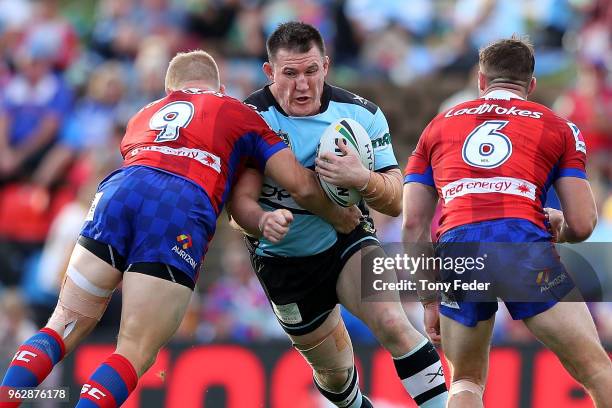 Paul Gallen of the Sharks is tackled during the round 12 NRL match between the Newcastle Knights and the Cronulla Sharks at McDonald Jones Stadium on...