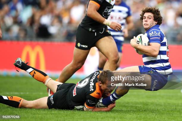 Adam Elliott of the Bulldogs is tackled during the round 12 NRL match between the Wests Tigers and the Canterbury Bulldogs at ANZ Stadium on May 27,...