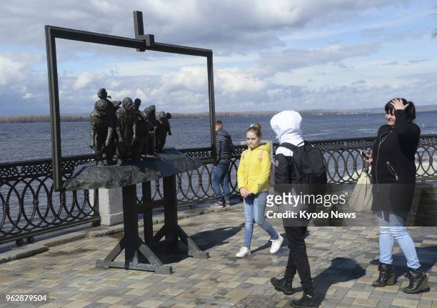 Photo taken on April 22 shows people looking at an artistic creation based on Ilya Repin's painting "Barge Haulers on the Volga" standing by the...