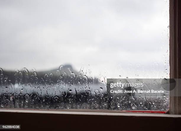 landscape of the coast and a mountain from a glass window with raindrops in terceira island in the azores islands, portugal. - storm outside window stock pictures, royalty-free photos & images