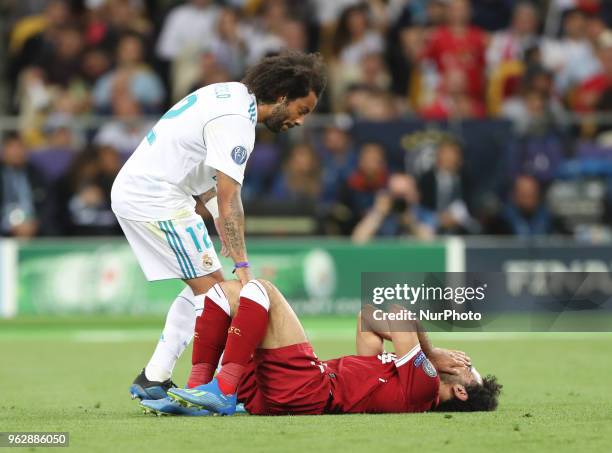 Liverpool's Egyptian forward Mohamed Salah is comforted by Real Madrid's Marcelo as he leaves the pitch after injury during the UEFA Champions League...