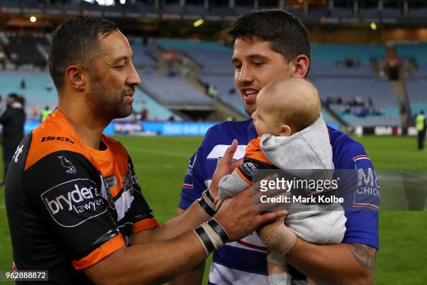 Benji Marshall of the Tigers reaches out to take Fox Marshall from Jeremy Marshall-King of the Bulldogs after the round 12 NRL match between the...