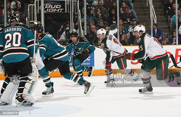 Mikko Koivu and Andrew Brunette of the Minnesota Wild chase down the puck behind Douglas Murray, Rob Blake and Evgeni Nabokov of the San Jose Sharks...