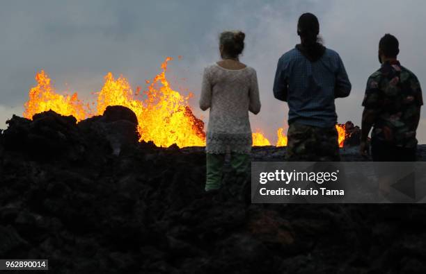 Onlookers watch as lava from a Kilauea volcano fissure erupts in Leilani Estates, on Hawaii's Big Island, on May 26, 2018 in Pahoa, Hawaii. The Big...