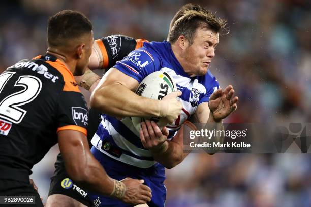 Brett Morris of the Bulldogs is tackled during the round 12 NRL match between the Wests Tigers and the Canterbury Bulldogs at ANZ Stadium on May 27,...