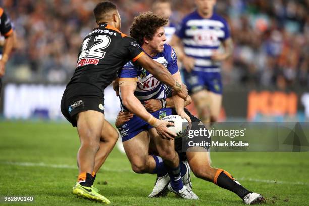 Adam Elliott of the Bulldogs looks to pass as he is tackled during the round 12 NRL match between the Wests Tigers and the Canterbury Bulldogs at ANZ...