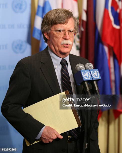 Three quarter length portrait of politician John Bolton speaking at the United Nations headquarters in New York City, New York with colorful flags in...