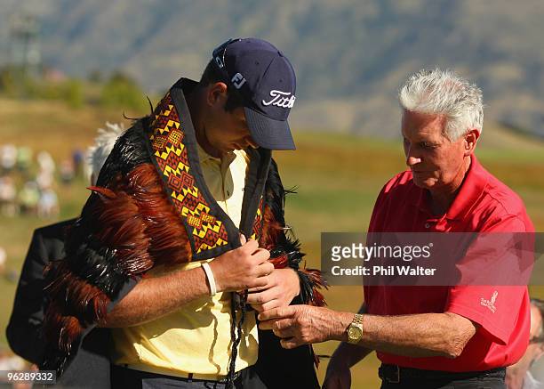 Sir Bob Charles helps Robert Gates of the USA with his feather cloak following day four of the New Zealand Open at The Hills Golf Club on January 31,...