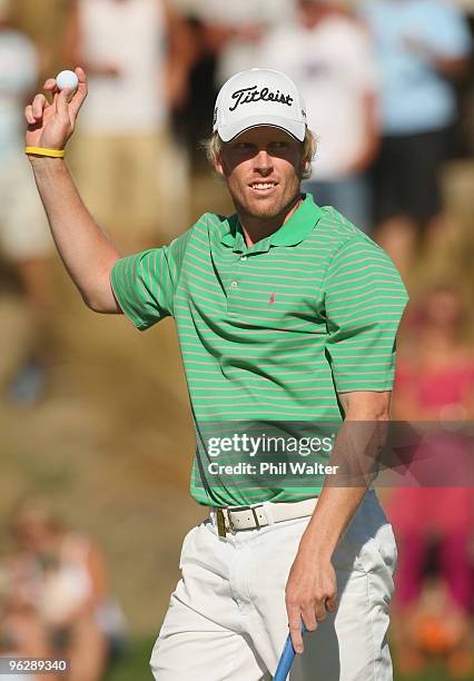 Andrew Dodt of Australia holds up his ball after sinking his putt on the 18th green during day four of the New Zealand Open at The Hills Golf Club on...