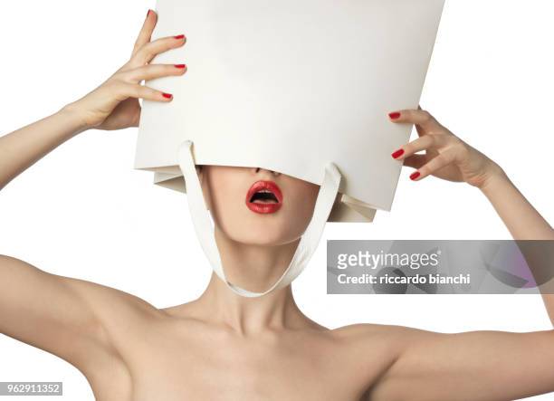 naked woman with red lips and polish enters into the bag - blind white background stock pictures, royalty-free photos & images