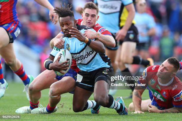 James Segeyaro of the Sharks is tackled by Connor Watson of the Knights during the round 12 NRL match between the Newcastle Knights and the Cronulla...