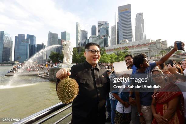 Kim Jong Un impersonator, Howard X, makes an appearance with Singapore's local food, chicken rice and durian at Merlion Park on May 27, 2018 in...