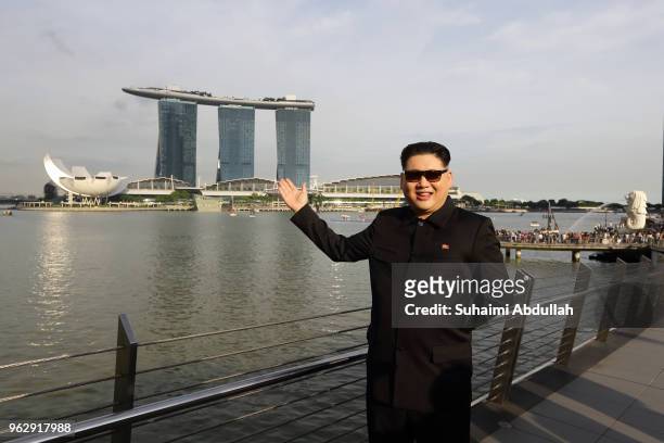 Kim Jong Un impersonator, Howard X, poses for a photo at Jubilee Bridge with the Marina Bay Sands at Marina Bay on May 27, 2018 in Singapore. The...