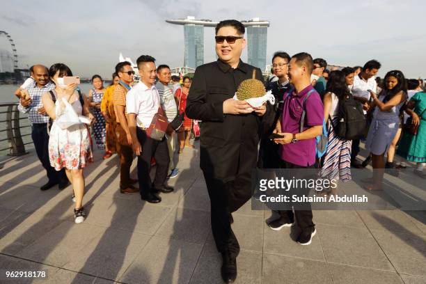 Kim Jong Un impersonator, Howard X, makes an appearance holding Singapore local fruit, the durian at Merlion Park on May 27, 2018 in Singapore. The...
