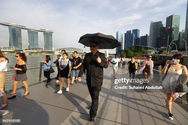 Kim Jong Un impersonator, Howard X, walks along the Jubilee Bridge as he makes an appearance at Marina Bay on May 27, 2018 in Singapore. The proposed...