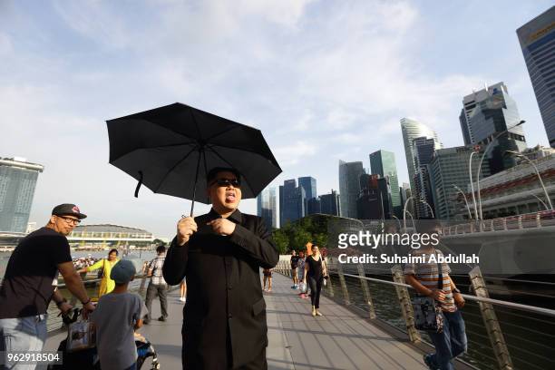 Kim Jong Un impersonator, Howard X, walks along the Jubilee Bridge as he makes an appearance at Marina Bay on May 27, 2018 in Singapore. The proposed...
