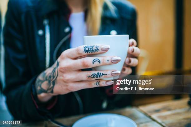 close-up of tattooed woman's hand with coffee - tattoo closeup stock pictures, royalty-free photos & images