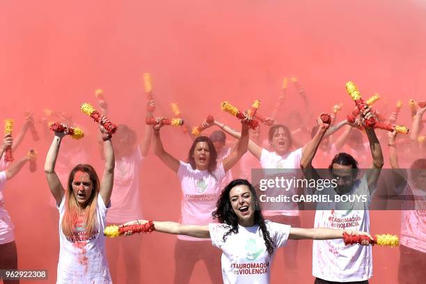 Anti-bullfighting protesters throw red flair representing bull´s blood during a demonstration as a part of the campaign "Bullfighting is Violence "...